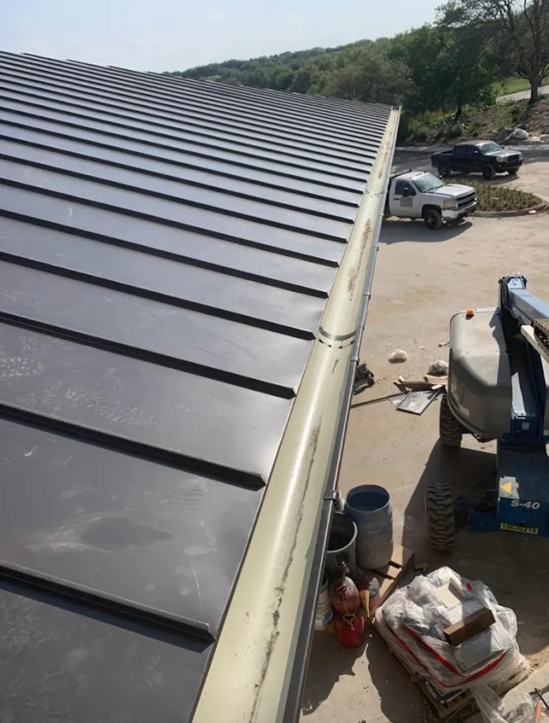 Standing seam panel and gutter detail on a metal roofing jobsite in Geneva